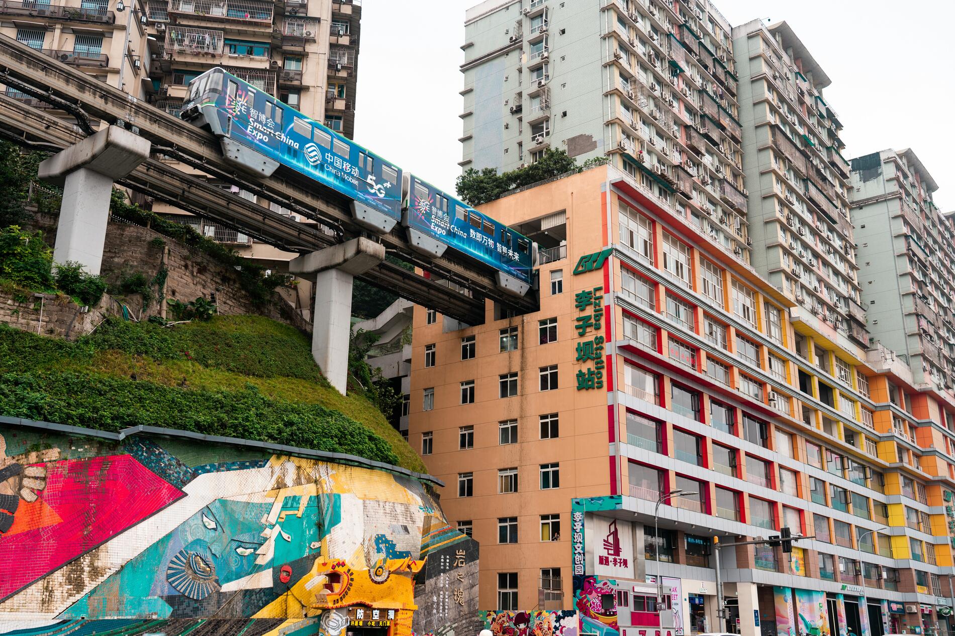 The architecture defies logic: the Monorail Line 2 train literally passes through the interior of a residential building at Liziba station. Eight stories high and causing no shaking or disturbance, it is a perfect example of how this vertical city turns every obstacle into a futuristic solution. Photo: Darmau. Photo Darmau. Chongqing. China.