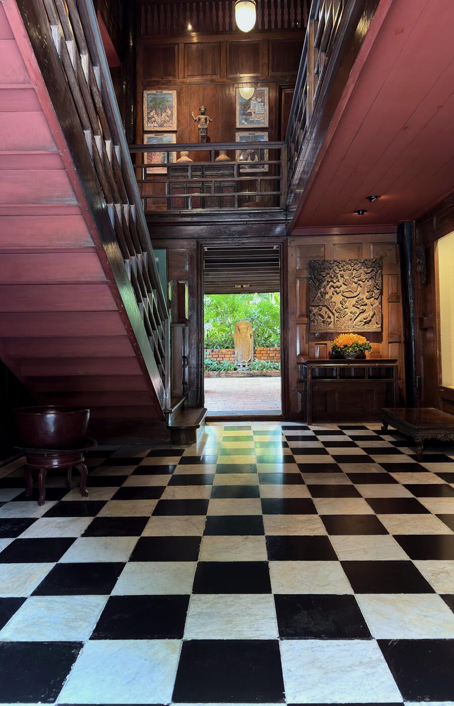 Entrance hall of the Jim Thompson House Museum featuring a Western-style staircase.